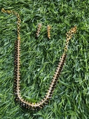 సాంప్రదాయ నల్ల పూసల నెక్లెస్ సెట్, మంగళసూత్ర-శైలి నెక్లెస్‌తో పాటు సరిపోయే చెవిపోగులు. యొక్క చిత్రం